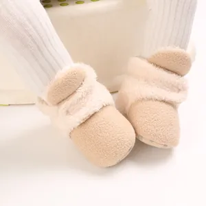 Primer plano de botas de nieve beige para bebé con forro polar y cierre de velcro