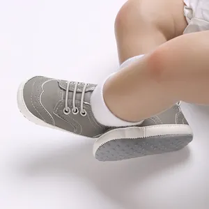 Detailopname van grijze baby-loopschoenen met zachte antislipzolen en witte gripstippen