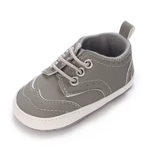 Detailweergave van grijze baby brogue loopschoen met zachte witte zool en veters.