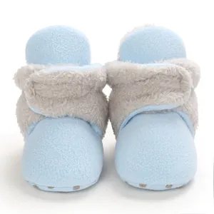 Detalle de botas de invierno para bebé en forro polar azul con ribete gris y suelas antideslizantes