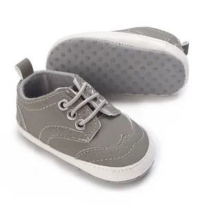 Detail van grijze baby loopschoenen met antislip zachte zool en stikseldetails.