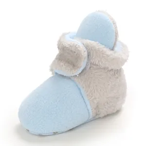 Vista lateral de botas de nieve para bebé en forro polar azul con suela blanda