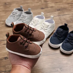 Detailweergave van de zachte babyloopschoenen in diverse kleuren op houten vloer