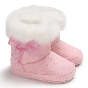 Soft warm pink baby snow boots featuring white faux fur trim and a glittery bow
