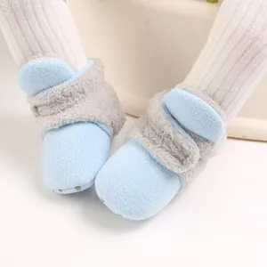 Primer plano de botas de forro polar para bebé en azul con ribete de piel sintética