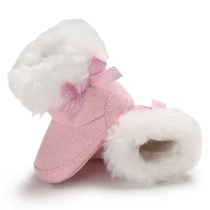 Detailed view of pink fleece-lined baby snow boots with fluffy white fur and bows