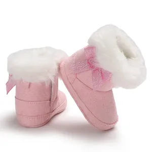 Warm pink baby snow boots with fluffy white fur lining and cute glitter bow detail.