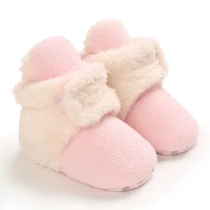Primer plano de botas de nieve rosas para bebé con forro de felpa suave y cierre de velcro