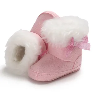 Detailed view of pink baby snow boots with soft white faux fur trim and glitter bow.