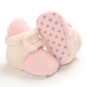 Gros plan détaillé de chaussures pour bébé en peluche rose avec semelle souple antidérapante