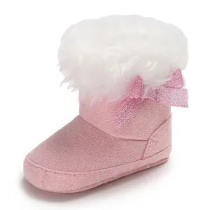 Detailed view of soft pink baby snow bootie with fluffy white faux fur and a glittery bow