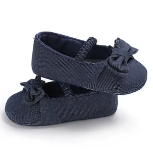 Dettaglio di scarpine per neonata blu navy con tessuto strutturato e fiocco.