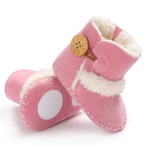 Detailansicht von rosa Baby-Schneestiefeln mit weichem Kunstfell und Holzknopf