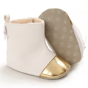 Detail showing plush lining and paw-print sole of white baby boots with gold toe