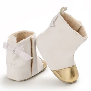 Detail of white baby winter boots with warm fleece lining and elegant gold toe cap.