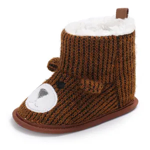 Detail of warm knitted baby snow boot with cute plush bear face and fleece lining.