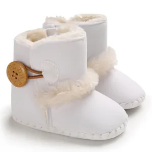 Nahaufnahme weißer Baby-Winterstiefel mit weichem Kunstfellbesatz und Holzknopf-Detail
