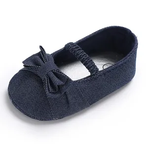 Primo piano di scarpa da camminata blu navy per neonata con fiocco decorativo e suola morbida