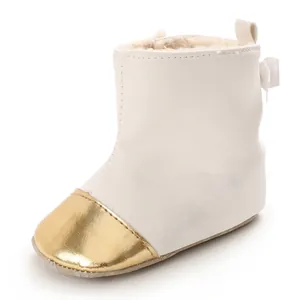 Detailed view of white baby winter boot featuring gold toe cap and warm plush lining