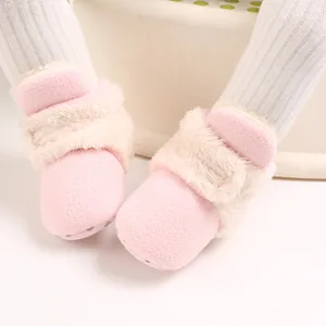 Primer plano detallado de botas de nieve de peluche rosas para bebé con forro cálido