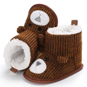 Close-up of brown knit baby snow boots featuring a cute bear face and warm plush lining