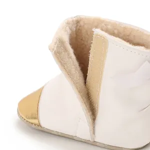 Detailed macro shot of white baby winter boots showing warm fleece lining and Velcro