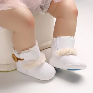Detailansicht warmer weißer Baby-Schneestiefel mit Pelzbesatz und Holzknopf-Verzierung.