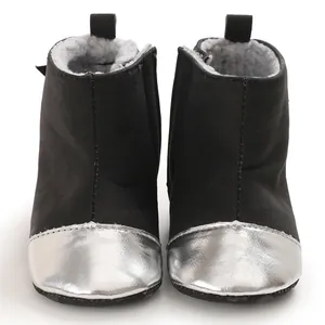 Close-up front view of black winter baby boots featuring a shiny silver metallic toe cap