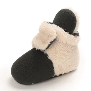 Detalle macro de botas de nieve para bebé de forro polar blanco y negro con velcro