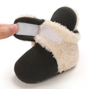 Primer plano de una bota de nieve para bebé con forro polar y detalle de velcro.