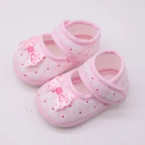 Nahaufnahme der weichen Stoffstruktur und der gepunkteten Schleife rosa Babyschuhe