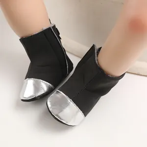 Close-up of baby winter boots with black fabric and silver metallic toe caps