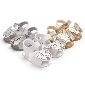 Vista detallada de sandalias para bebé con aplique de mariposa en plata, blanco y dorado.