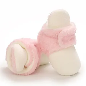 Botitas de peluche suaves para bebé en rosa y crema con cierre de velcro.