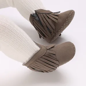 Detailed view of brown infant winter snow boots with fringe and soft anti-slip sole