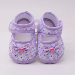 Nahaufnahme lilafarbene karierte Babyschuhe für Mädchen mit rosa gepunkteter Schleife