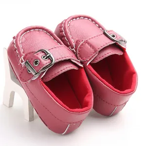 Detailed view of burgundy soft sole baby loafer with white stitching and metal buckle