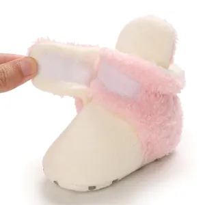 Detalle del cierre de velcro en las botas de nieve de felpa rosa suave para bebés