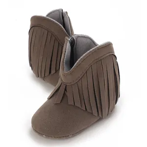 Close-up view of brown soft suede baby snow boots featuring stylish decorative fringe details