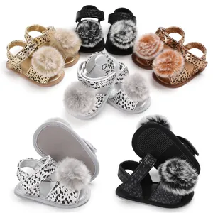 Detailed view of baby leopard print sandals with soft pom-poms and non-slip soles.