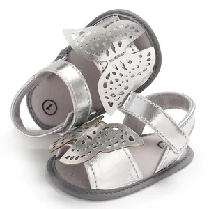 Primer plano de sandalias con mariposa para bebé en color plata metálico brillante