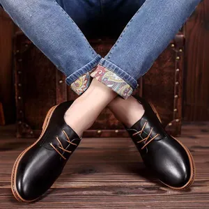 Primer plano de zapatos Derby de cuero negro para hombre con vaqueros en suelo de madera