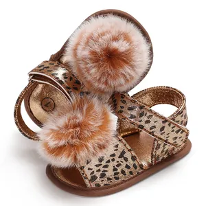 Vue détaillée de sandales léopard pour bébés filles avec pompons en fourrure marron