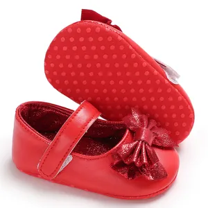 Vue détaillée des chaussures de princesse pour bébé rouges avec nœud et semelle antidérapante