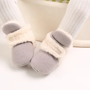 Primer plano de botas de nieve grises para bebé con suave ribete de color crema
