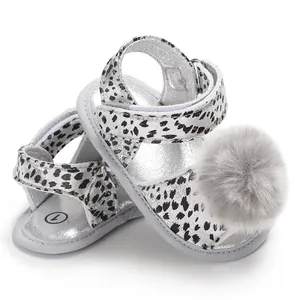 Macro view of stylish baby leopard print sandals featuring a soft gray pom-pom detail