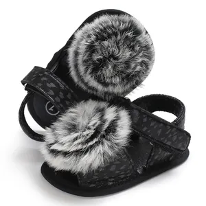 Vue détaillée des chaussures de marche pour bébé avec pompons en fourrure grise et motif léopard