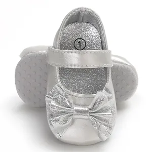 Vue détaillée de chaussures de marche princesse pour bébé argentées avec un grand nœud brillant