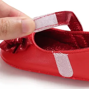 Détail de la sangle auto-agrippante sur une chaussure de princesse rouge pour bébé