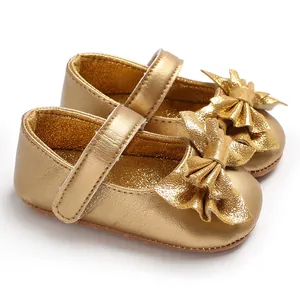 Vue détaillée des chaussures de marche princesse dorées pour bébé avec un joli nœud brillant